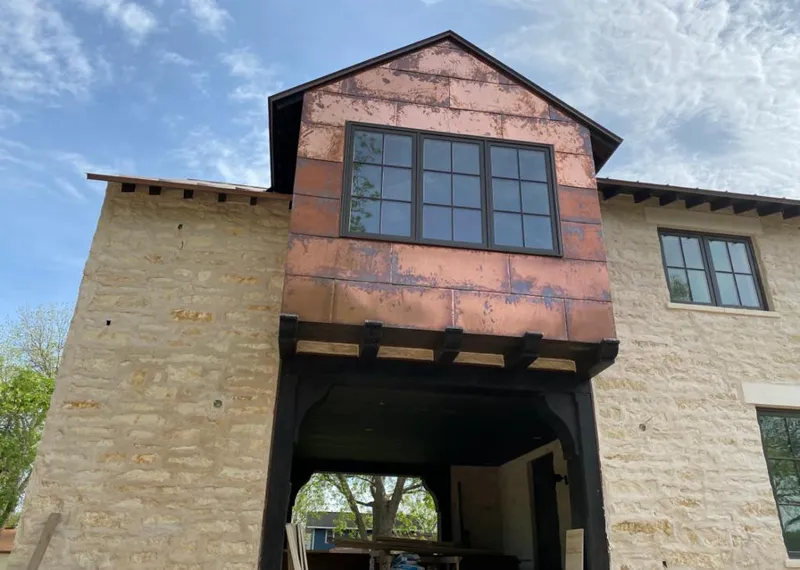 Copper metal panel facade on a stone building for Skylight Installation in West Earl