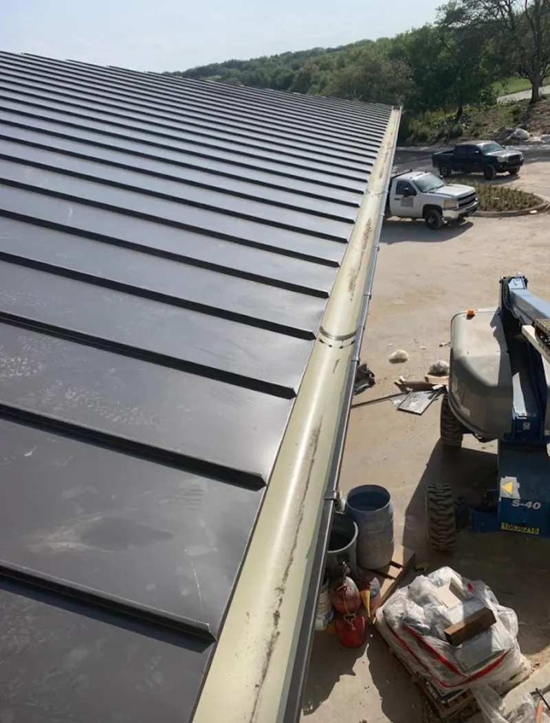 Standing seam panel and gutter detail on a metal roofing jobsite in West Earl